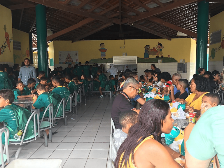 Visitantes fazendo lanche na companhia dos atendidos da EC